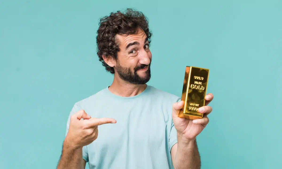 Un homme tenant un lingot d'or dans la main