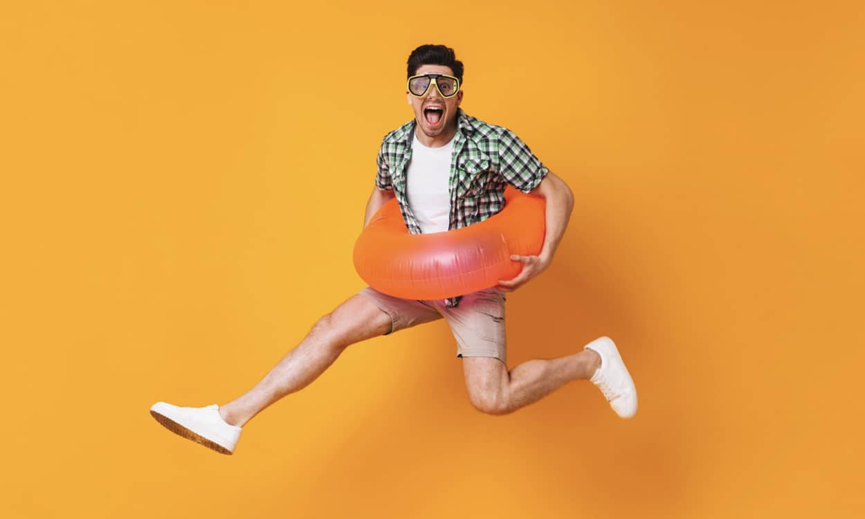 Un homme heureux qui saute avec une bouée gonflable
