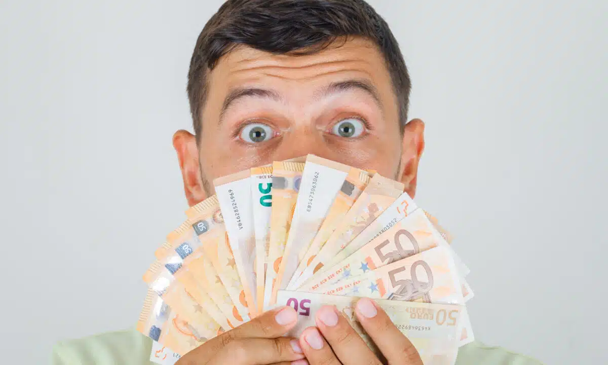 Un homme derrière une liasse de billets de 50 euros