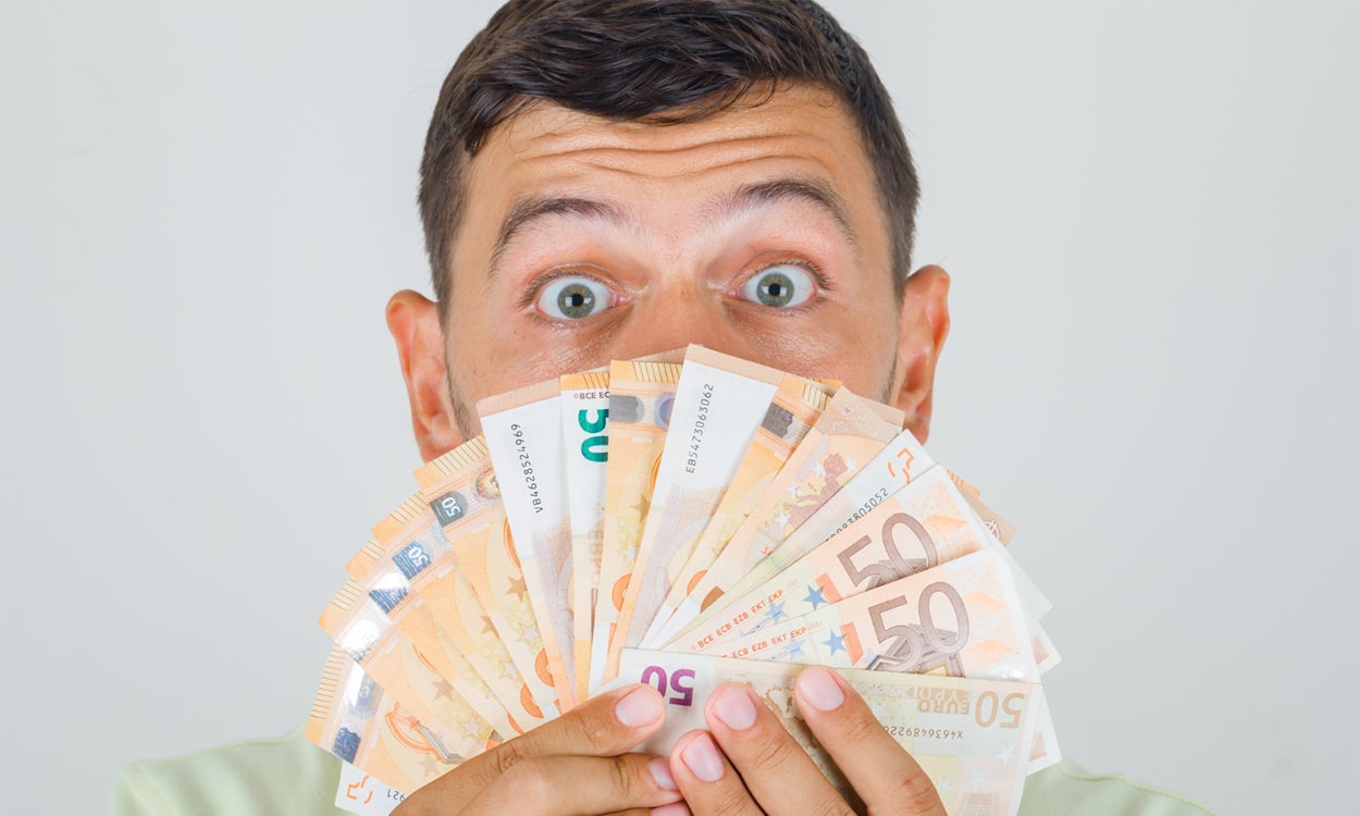 Un homme derrière une liasse de billets de 50 euros