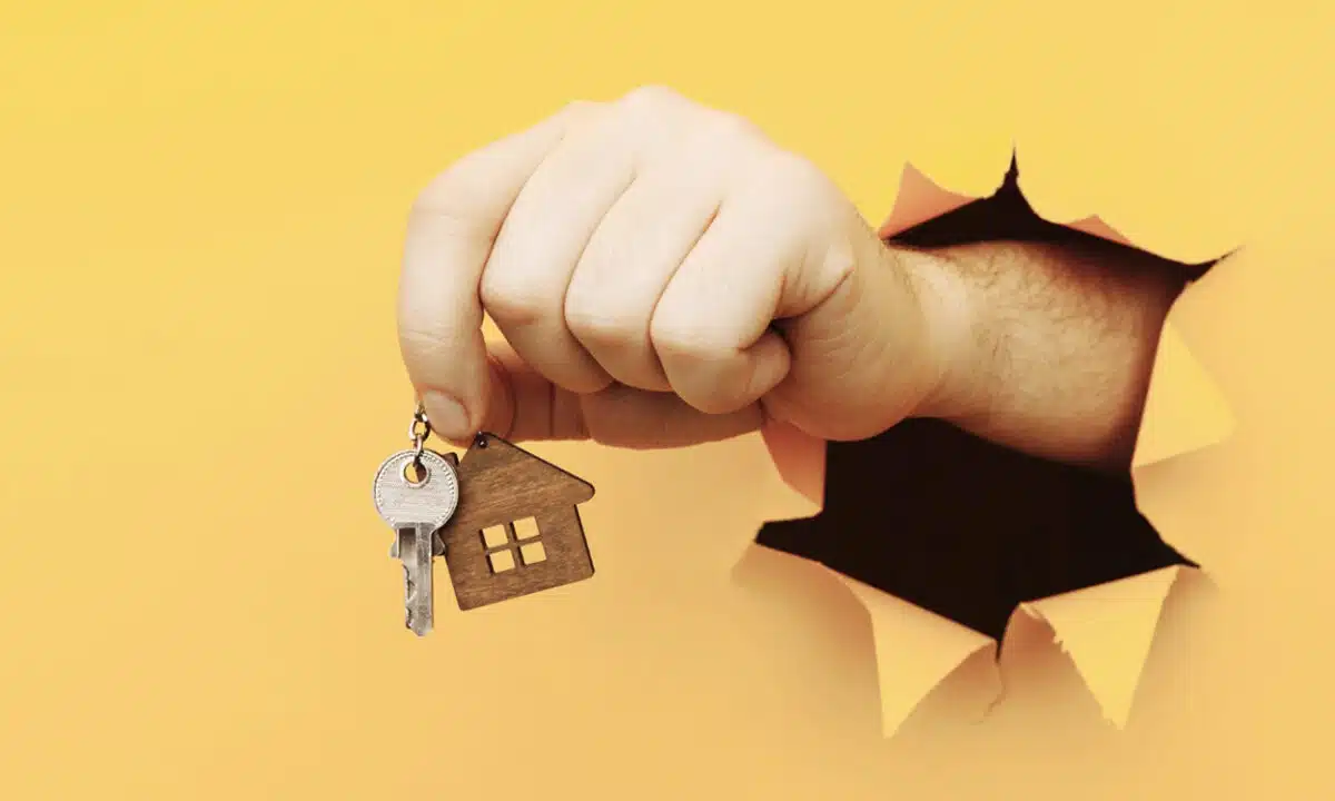 Main qui tend la clés d'une maison après une acquisition immobilière