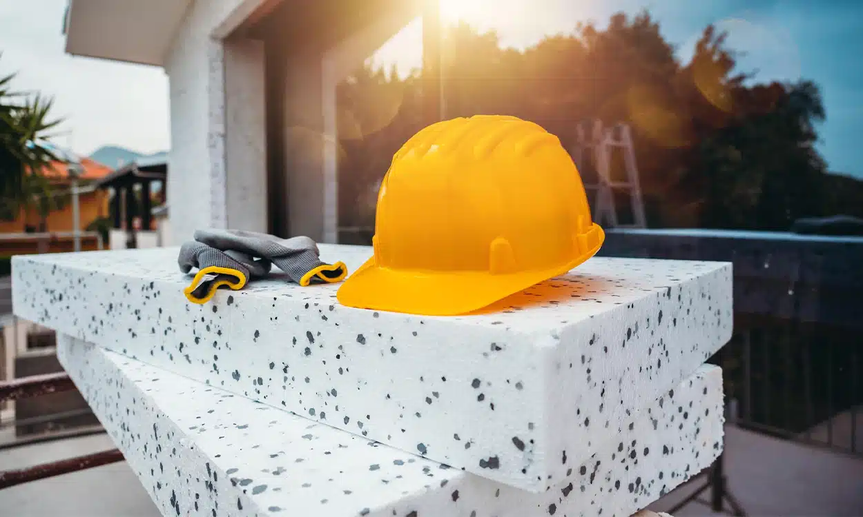 Panneaux d'isolant extérieur avec un casque de chantier et des gants de protection