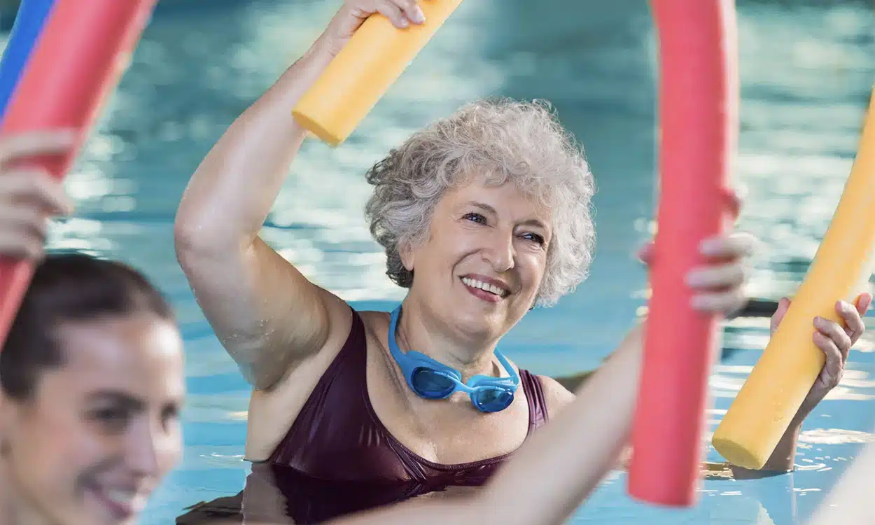Femme de 60 ans en cours d'aquagym pendant sa cure d'amaigrissement