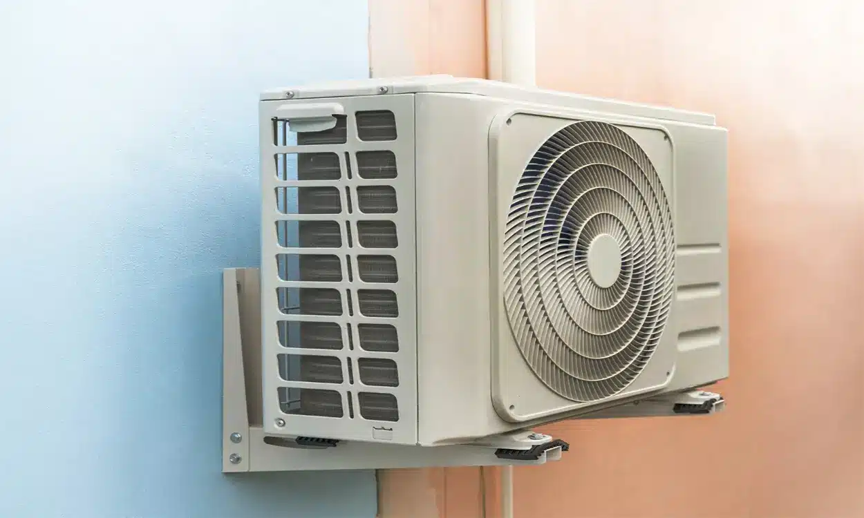 Moteur d'une pompe à chaleur installé contre un mur de maison