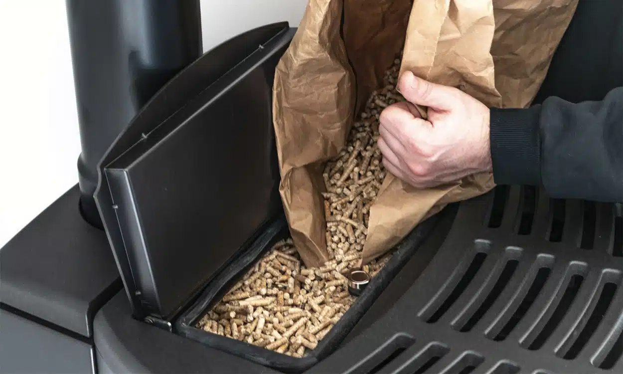Remplissage d'un poêle à granulés de bois avec un sac de pellets de 15kg