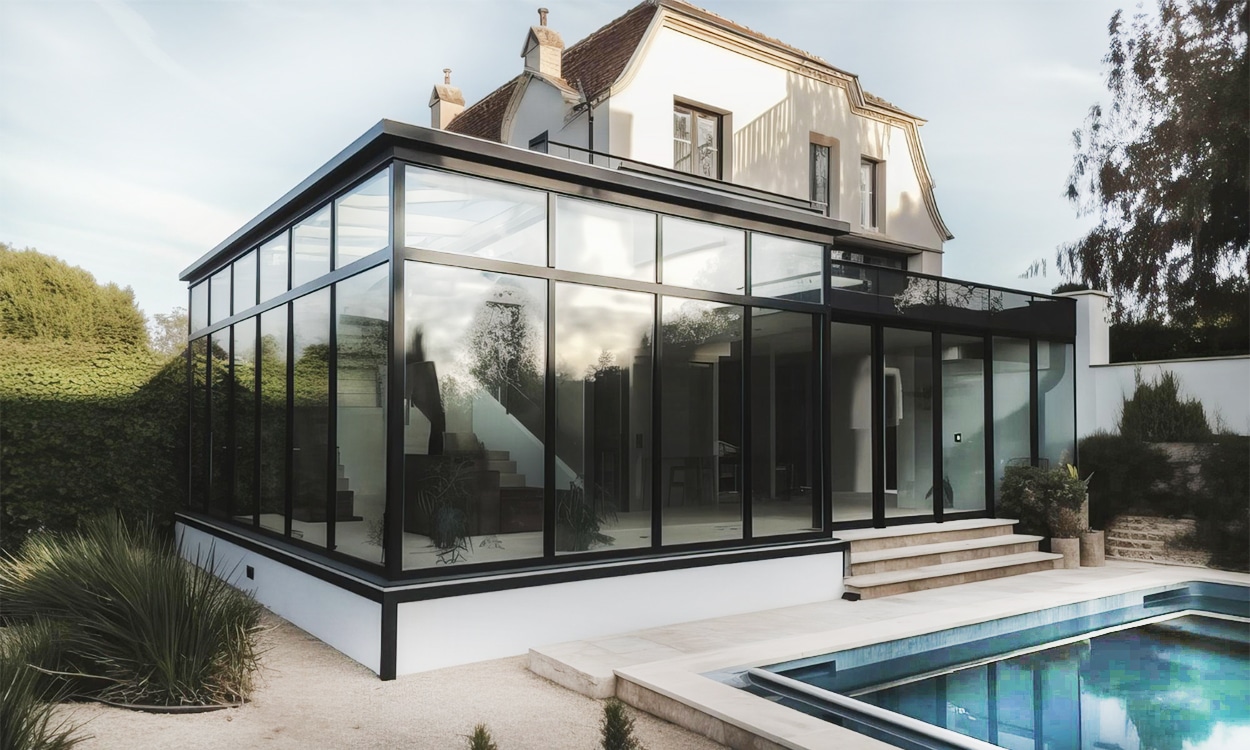 Maison avec une grande véranda bioclimatique en aluminium noir au bord d'une piscine
