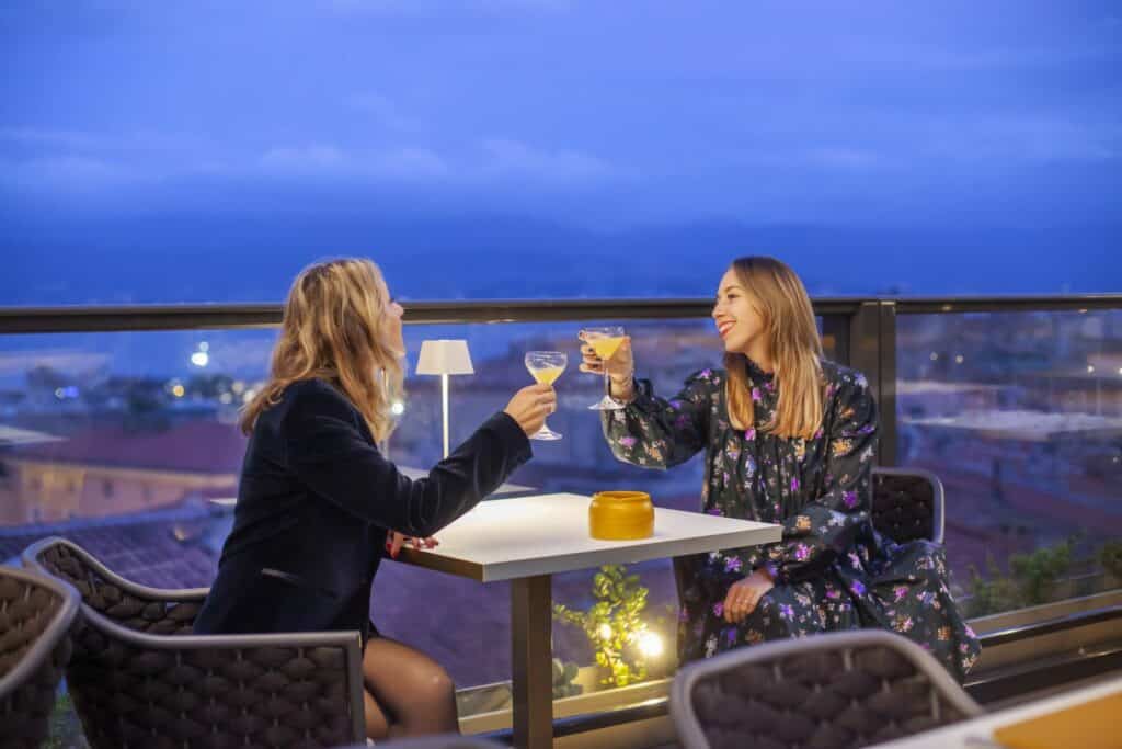 Deux jeunes femmes qui boivent un cocktail sur le rooftop de l'Hôtel Fesch à Ajaccio