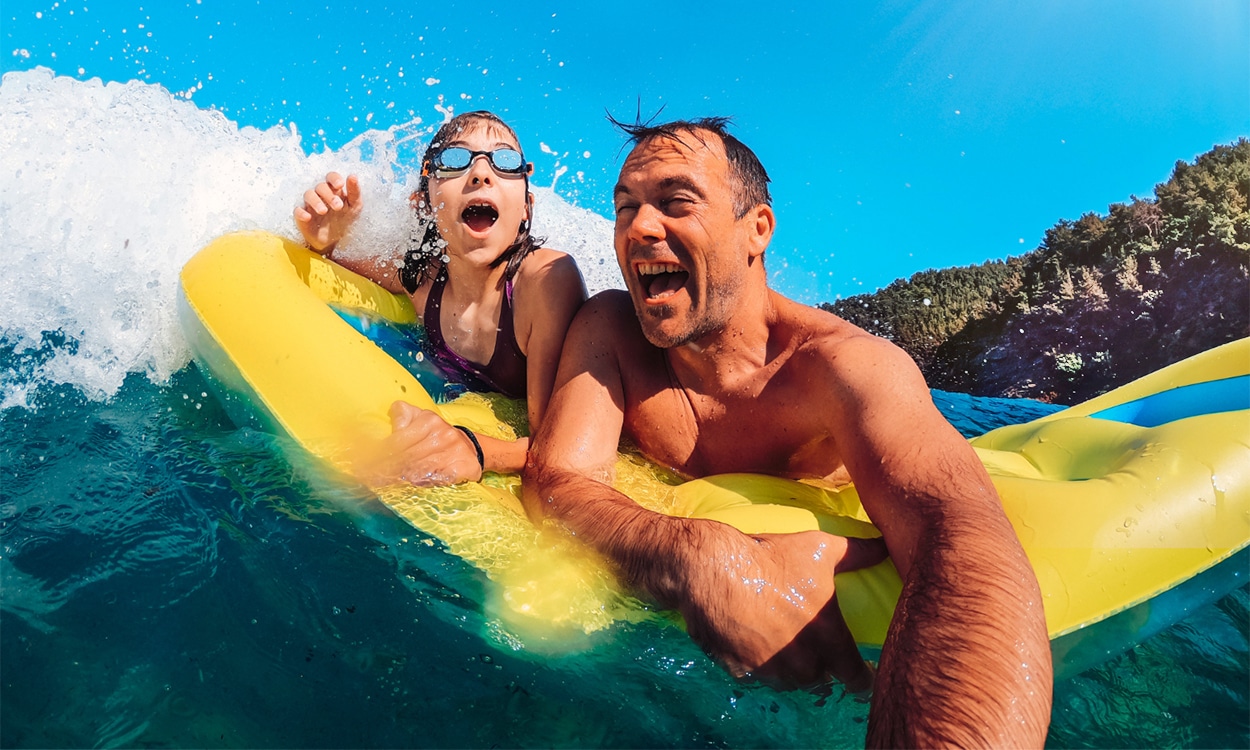 Père et sa fille qui s'amusent dans les vagues sur une bouée
