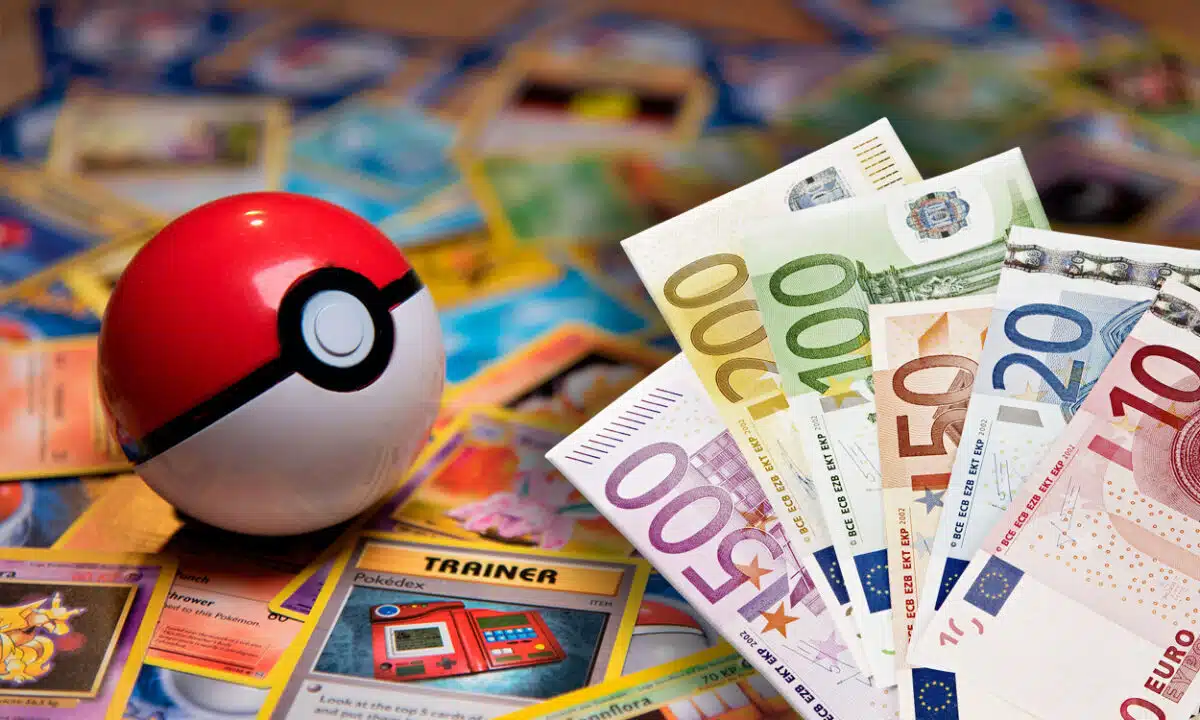 Une pokeball posée sur des cartes Pokémon avec une liasse de billets d'argent en euros