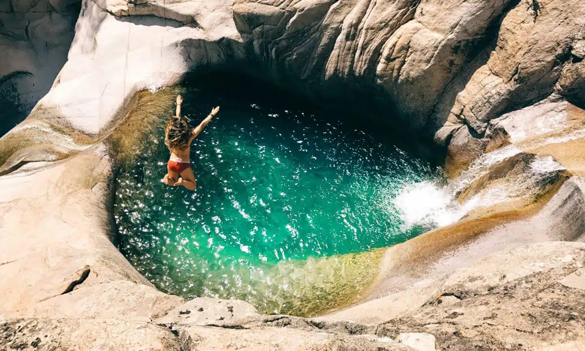 Jeune femme qui saute dans un bassin du Canyon de la Purcaraccia