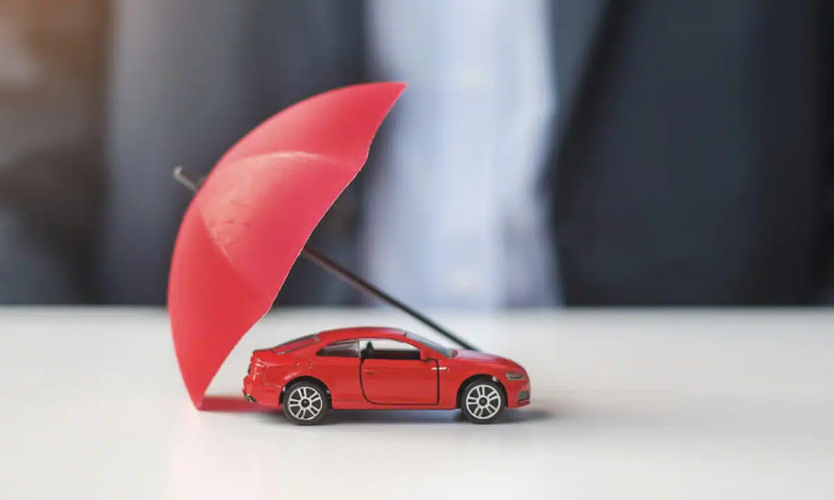 Voiture protégée par un parapluie pour une assurance voiture