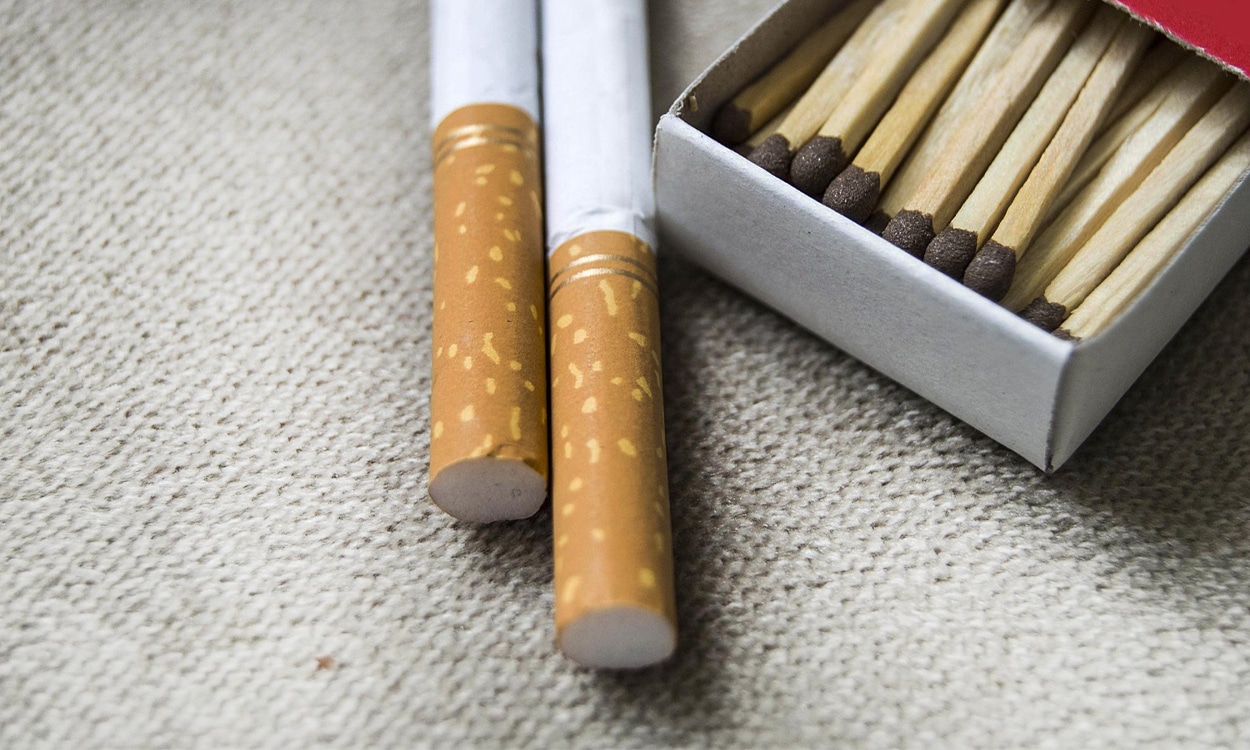 Deux cigarettes posées à côté d'un paquet d'allumettes ouvert