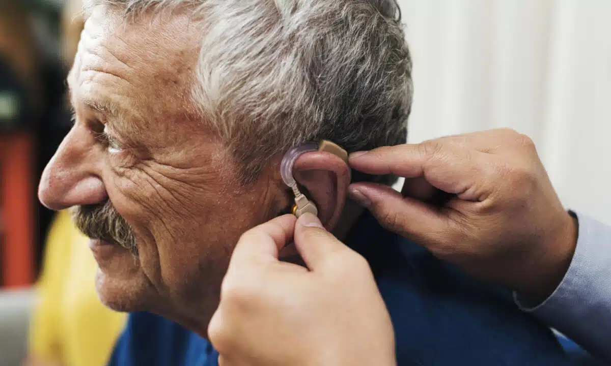 Installation d'une prothèse auditive sur l'oreille d'une personne agée