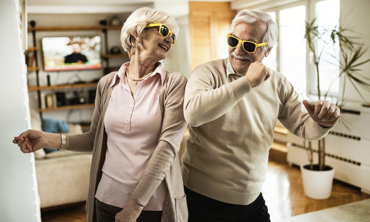 Couple de seniors heureux qui dans dans leur salon avec des lunettes de soleil