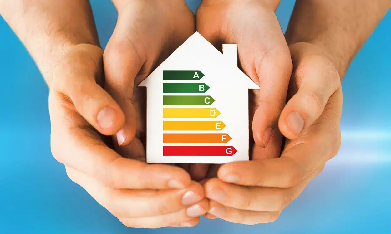 Maison avec le sigle de performance énergétique dans les mains d'un adulte et d'un enfant