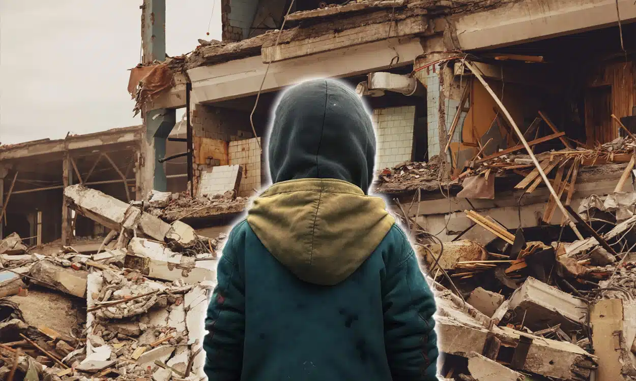 Un enfant de dos devant les ruines d'un immeuble