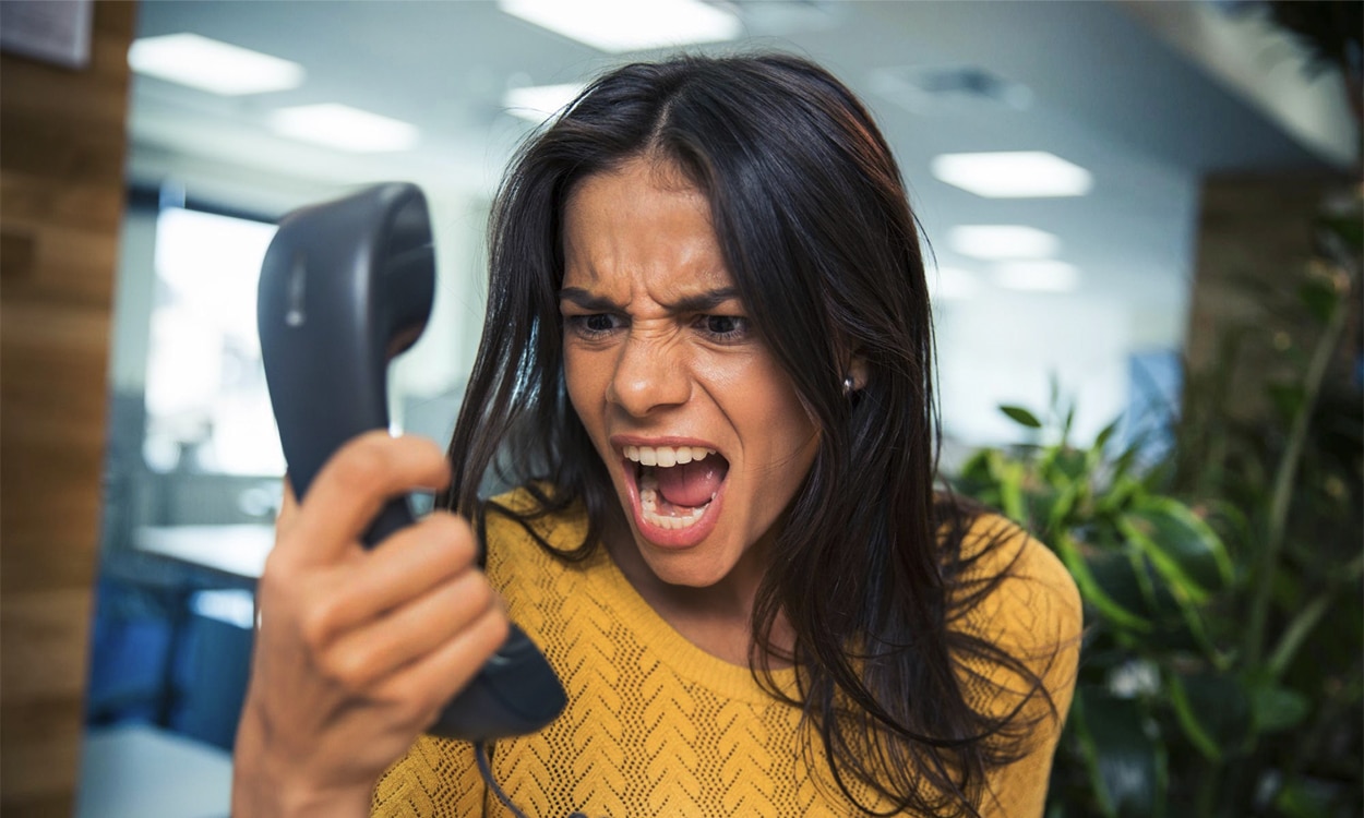 Une femme en colère qui tient sont téléphone