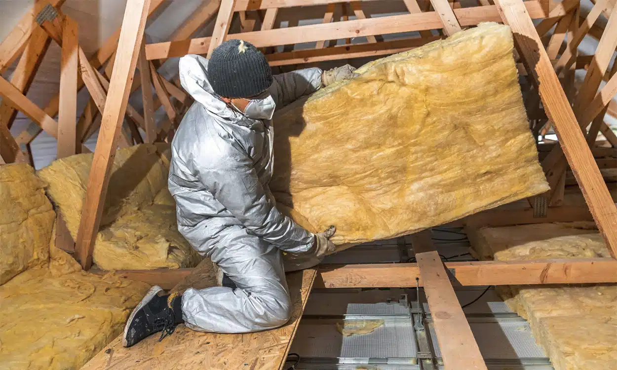 Travaux d'isolation des combles avec des rouleau de laine isolante