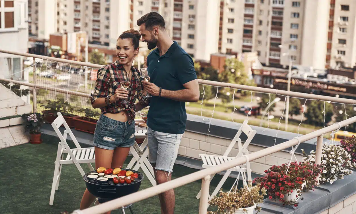 Couple qui fait un barbecue sur son toit terrasse aménagé