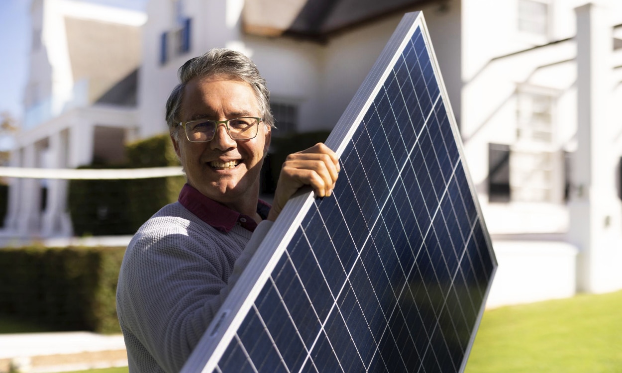 Un propriétaire qui porte une panneau solaire photovoltaïque