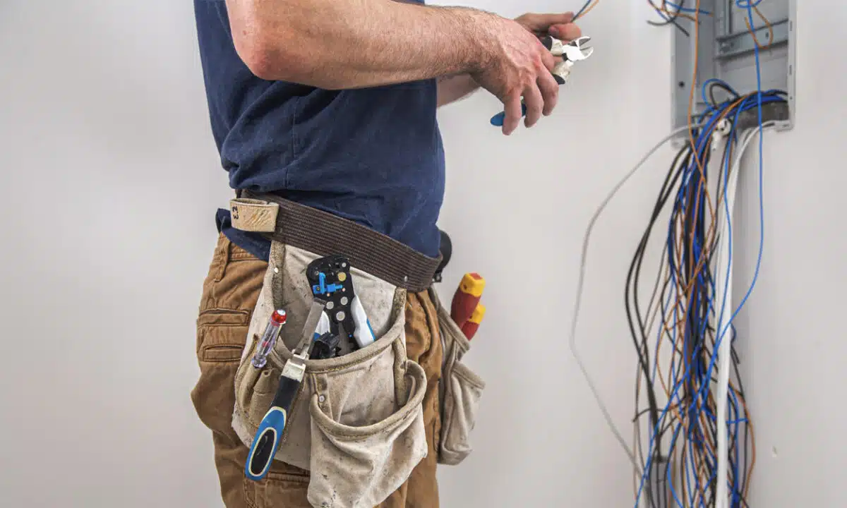 Un électricien qui s'occupe du câblage d'un tableau électrique