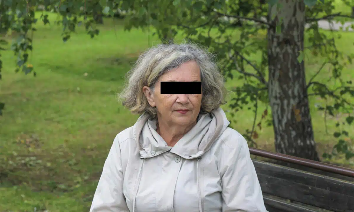 Femme de 60 ans anonyme assise sur le banc d'un parc