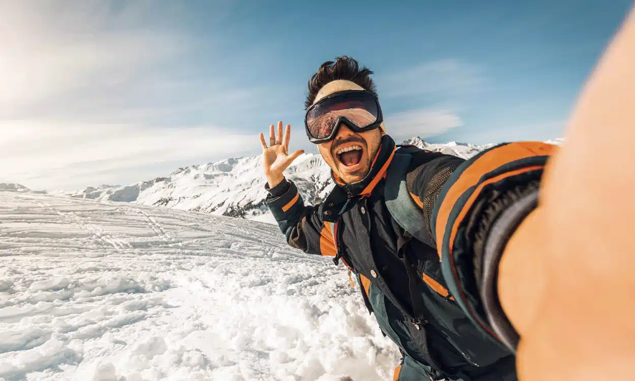 Un skieur qui se prend en selfie lors d'une descente sur une piste enneigée