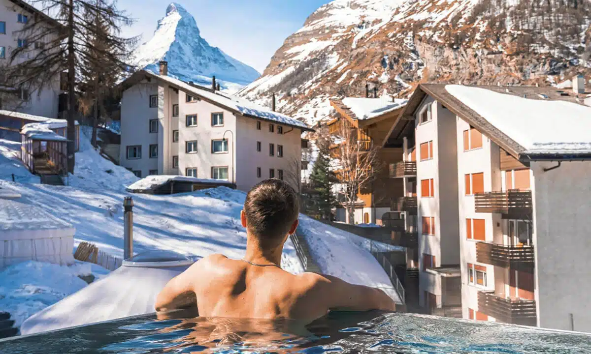un touriste qui se baigne dans la piscine extérieure d'un chalet dans une station de ski à la montagne