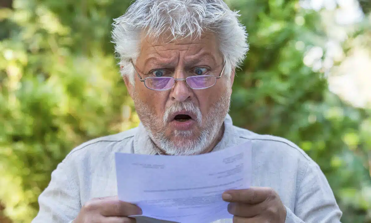 Un senior choqué en lisant une courrier papier